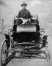 Man and dog in early automobile