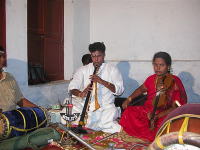 House concert in Mannargudi, three musicians playing percusion, woodwind and stringed instruments