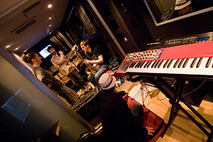 Band members inside the John Lennon Educational Tour Bus with a keyboard in the foreground.