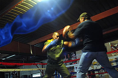 Boxer boxing with coach in the ring