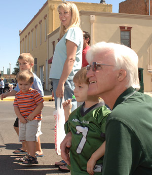Family watching the parade. Young boy wearing a Mean Green footbal jersey with the number 7