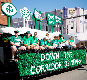 Down the corridor of years parade float featuring various historical University of North Texas emblems