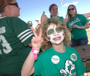 Young girl with face paint gesturing an eagle talon