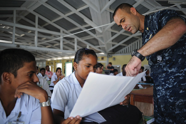 Lt. Michael  Kavanaugh (’05,’08 M.S.) speaks to school children in Guyana about mosquitoes that carry  infectious diseases, during a Continuing Promise 2010 community service event. (Courtesy of Oscar Sosa/U.S. Navy)