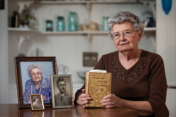 Ruth Ann Davison Torgerson ('50) is pictured with photos of her aunt, mother and husband and the Fannie Farmer cookbook that was a North Texas textbook almost a century ago. (Photo by Gary Payne)