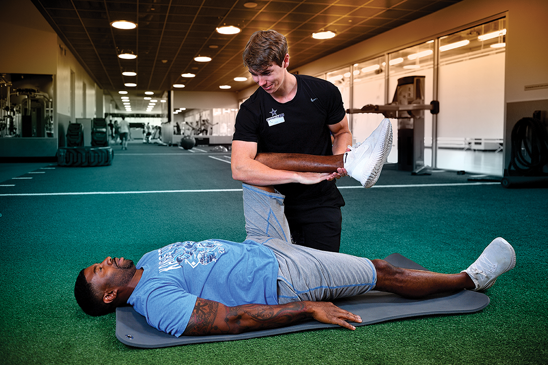 Alex Shaw assisting an athlete with leg extensions