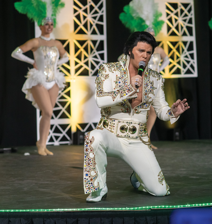 Elvis impersonator with Las Vegas style showgirls in the background