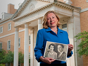 Pat Guseman is pictured with a photo of her mother and father, Vera and Ulys G. Knight ('25), in front of the Hurley Administration Building. (Photo by Jonathan Reynolds)