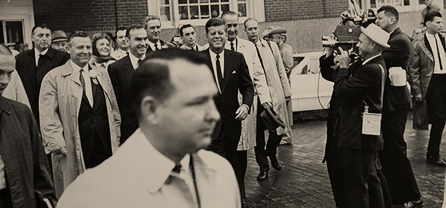 Mike Howard ('60), foreground, leaving the Texas Hotel in Fort Worth with President John F. Kennedy, Vice President Lyndon B. Johnson and other government officials. (Courtesy of Mike Howard)