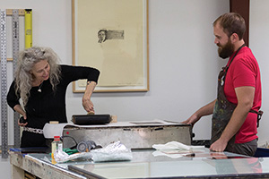 Printmaking master's student Preston Bradley, right, shows Kiki Smith, left, the capabilities of the P.R.I.N.T. Press equipment during a visit this fall. (Photo by Ann Graham)