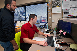 College of Business graduate Michael Paddack works on invoices with help from Jorge Rosas, left, at ProBuild, a building materials supply company. (Photo by Gary Payne)