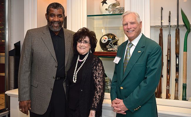 "Mean" Joe Greene, one of the 2013 alumni honorees, with Sara Sue and Don ('63) Potts at their home in Dallas during the Emerald Eagle Honors Kickoff event they hosted in November. (Photo by Michael Clements)