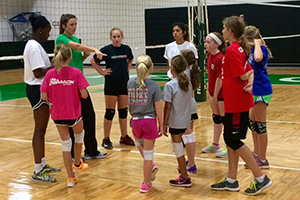Assistant coach Madison Barr, in green, coaches a volleyball camp. (Photo by T.C. Greene)
