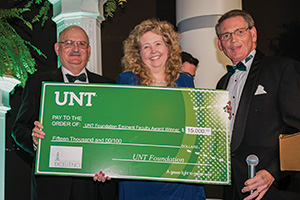 Angela Wilson, Regents Professor of chemistry, receives the Eminent Faculty Award cash prize from UNT Foundation board member Bob Sherman and President and CEO of the UNT Foundation Mike Mlinac. (Photo by Ahna Hubnik)