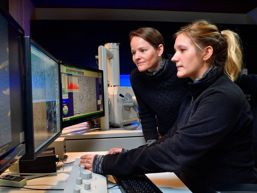 Two women at a a series of computer monitors