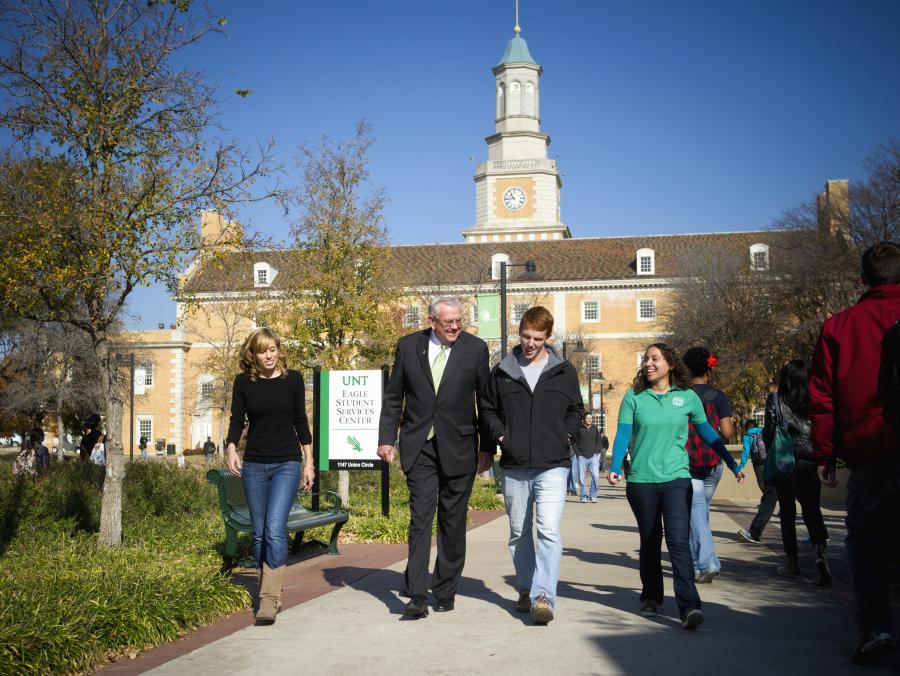 President Lane Rawlins walking with students on campus