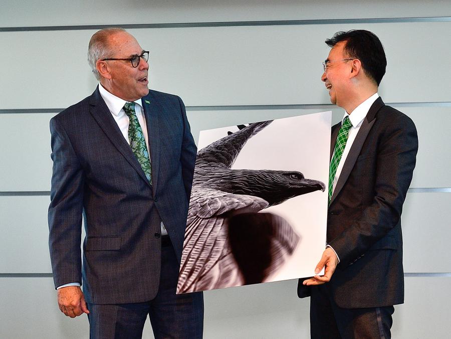 President Neil Smatresk presents NetDragon founder Dejian Liu with an eagle painting at the NetDragon Digital Research Centre launch announcement May 15. The centre will offer students and faculty sponsored research and technology development opportunitie