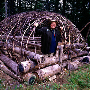 Tim Smith constructing a shelter from branches and logs