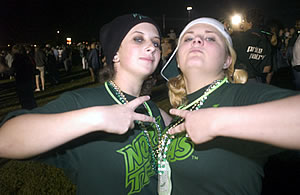 Two students posing with green outfits