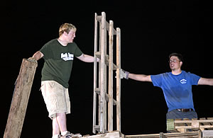Two students helping to build bonfire