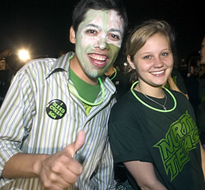 Two students with green attire and painted green and white face