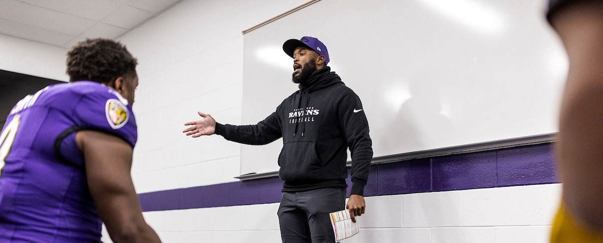 Zach Orr speaks to players in a locker room