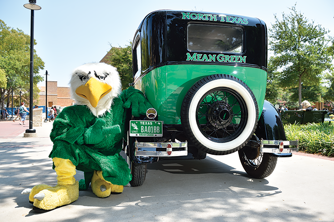 UNT mascot Scrappy poses with a UNT Model T car with UNT license plate