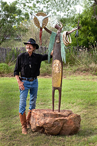 William "Bill" Worrell ('74 M.F.A.) at his Texas studio with his bronze sculpture Mystery, Power and Energy (Photo by Wallace Bosse)