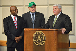 From left, Dallas Mayor Pro Tem Tennell Atkins and Dallas City Council member Adam Medrano ('01) present a proclamation to UNT Athletic Director Rick Villarreal in Dallas in January. (Photo by Michael Clements)