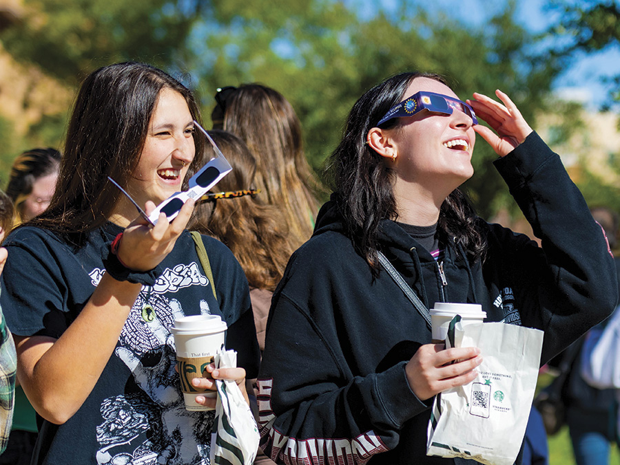 Students with specialized glasses view and eclipse