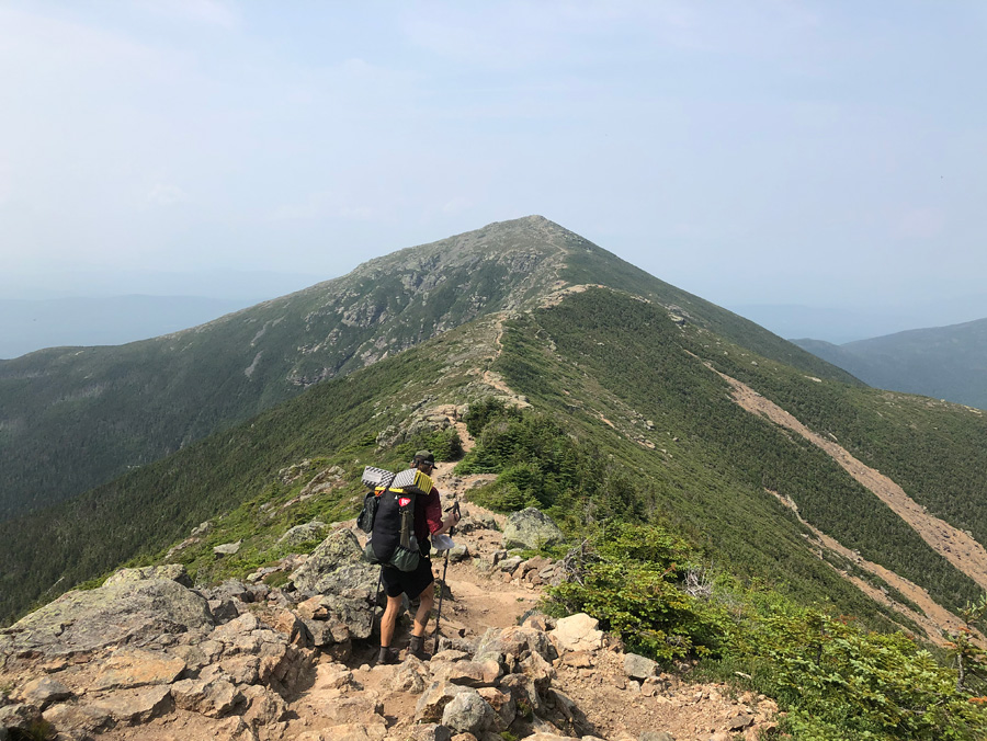 Brett Luce hiking along the crest of a mountain