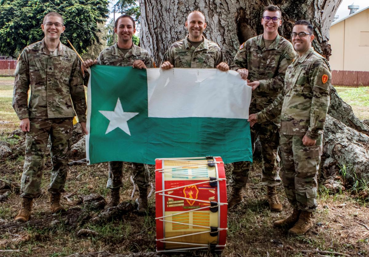 Photo of five military band members holding the UNT battle flag