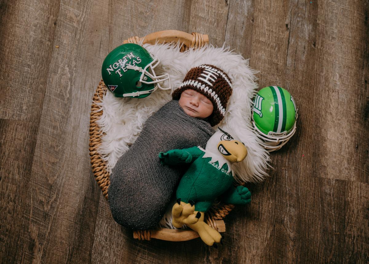 Photo of baby Hagan Withers surrounded by Mean Green football memorabilia