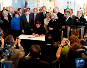 President Gretchen M. Bataille (first from left) watches as Gov. Rick Perry signs into law a state program to help emerging research universities like UNT. (Courtesy of University of Texas at Dallas)