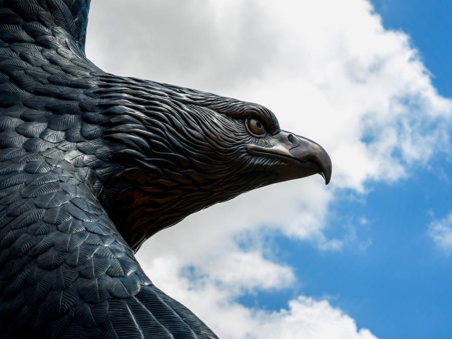 Bronze Eagle statue against a blue sky.