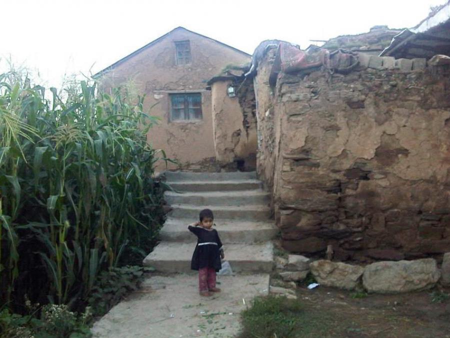 Child standing in front of a stone building