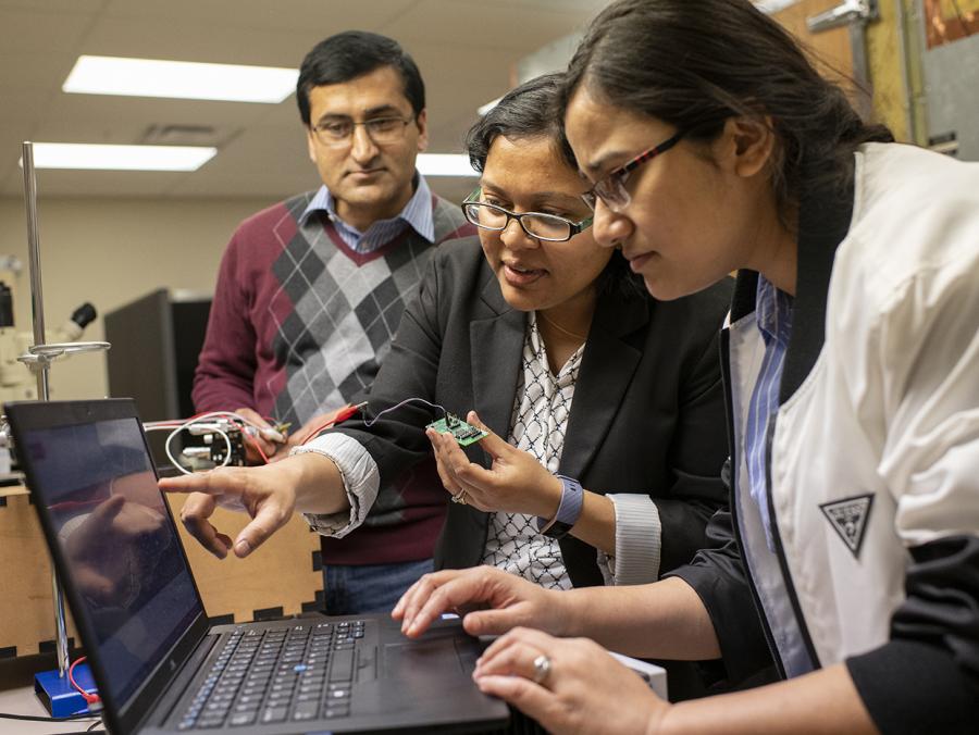 Electrical Engineering Assistant Professor Ifana Mahbub (center) works with Ph.D. students Pashupati Adhikari (left) and Nishat Tasneem on her electro-wetting project.