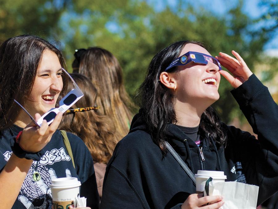 Students with specialized glasses view and eclipse