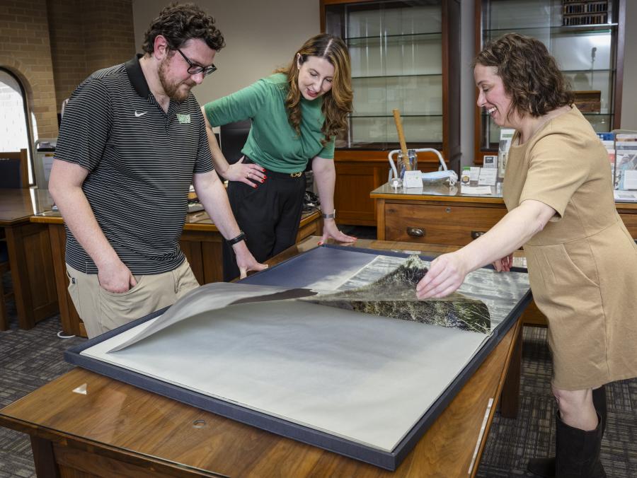 Photo of UNT faculty and staff examining document in the Special Collections room