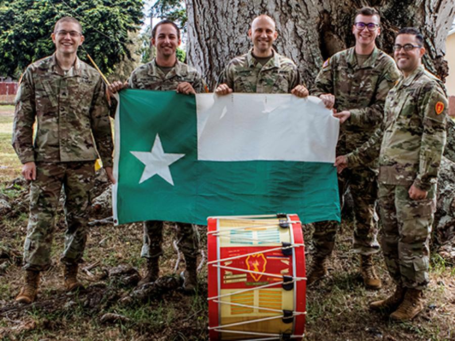 Photo of five military band members holding the UNT battle flag