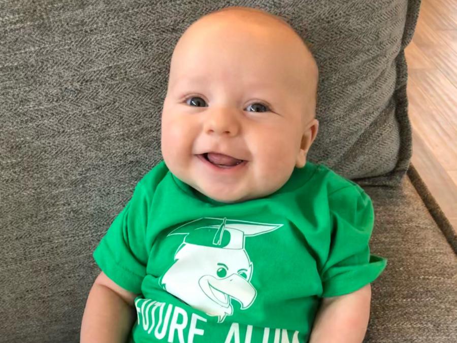 Photo of baby Emet Eichler wearing a green UNT T-shirt with the words "Future Alum"