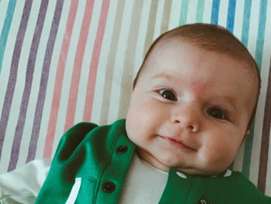 Photo of baby Quinn Lilley in green letter jacket with the text "North Texas" 