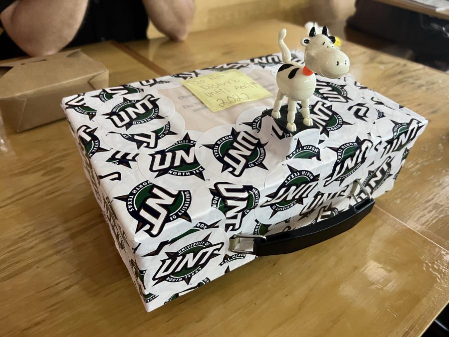 Photo of time capsule wrapped in stickers with UNT logo