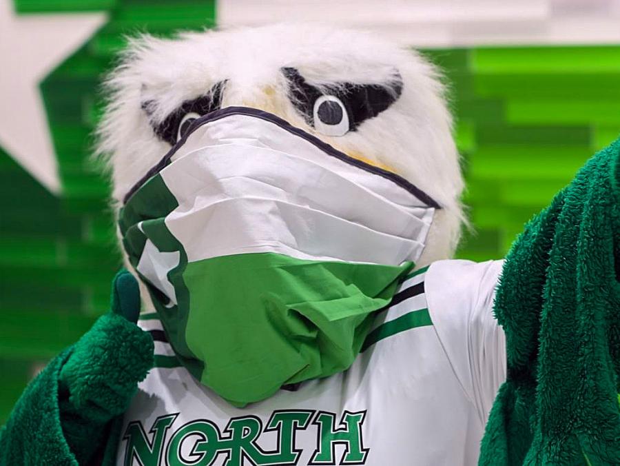 UNT's Scrappy Mascot wears his mask and gives a thumbs up