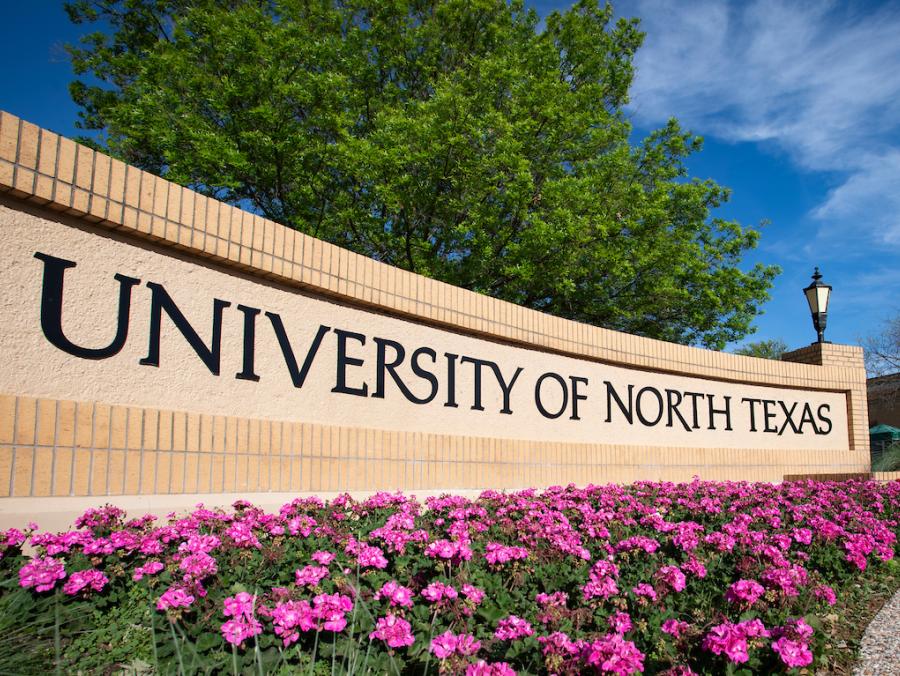 Photo of monument with the words "University of North Texas" and flowers in front of it