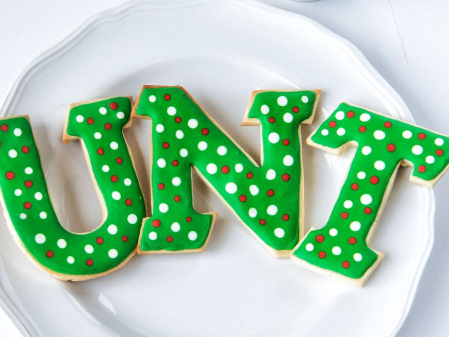Green UNT cookie letters sit on a white plate.