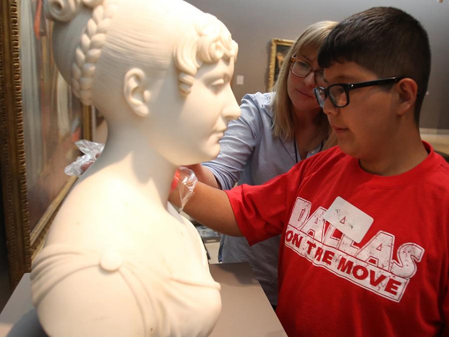 student touching a sculpture