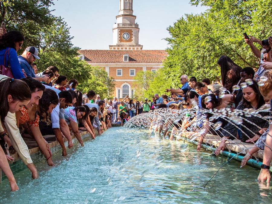 Photo of students dipping class rings in library fountains 