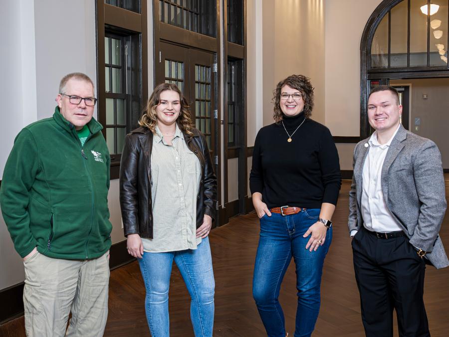 Carl Parsons, Shelby Simmons Haney ('23), Neely Shirey ('09) and Kirk Plum ('18, '18 M.S.) pose in the historic Curry Hall corridor. 