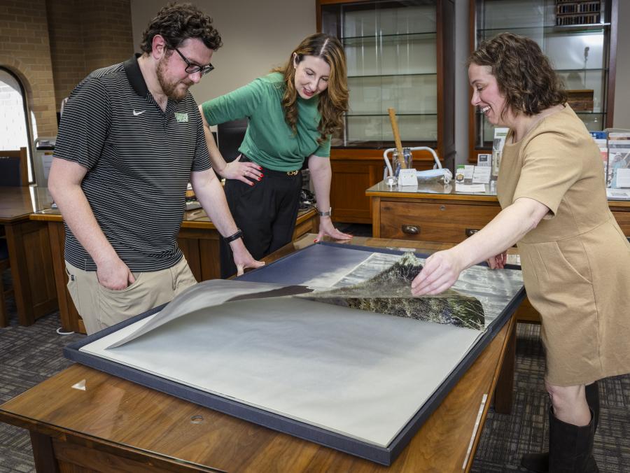 Photo of UNT faculty and staff examining document in the Special Collections room